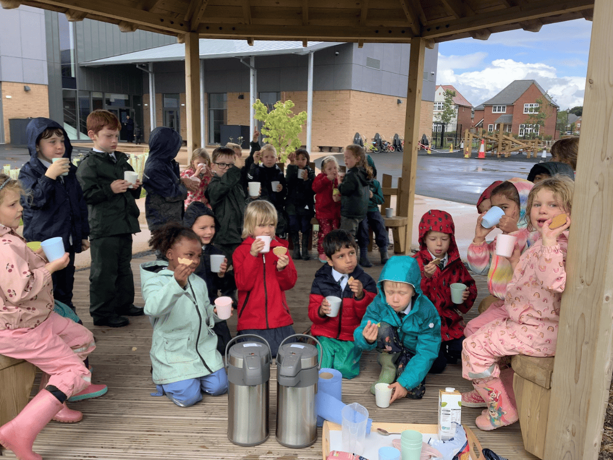 Pupils in forest school having a hot chocolate.