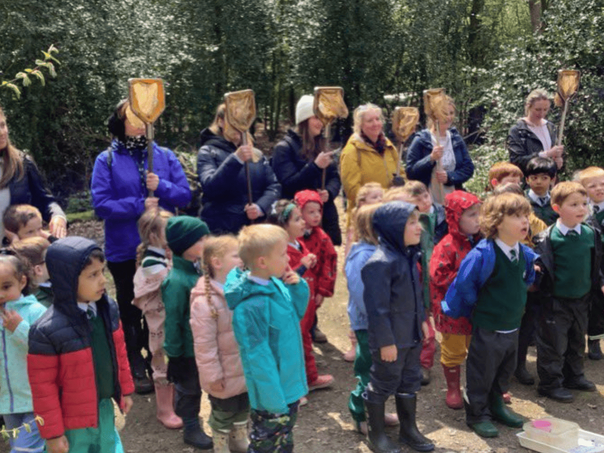 Woodford Primary School pupils from Reception listen to a story at Lower Moss Wood