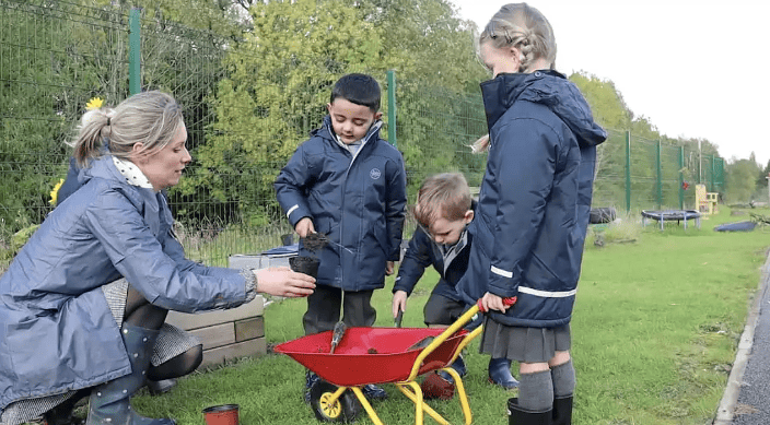 Pupils playing with a wheelbarrow